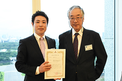 贈呈式の様子(左:古賀助教,右:水田邦雄 選考委員長)
